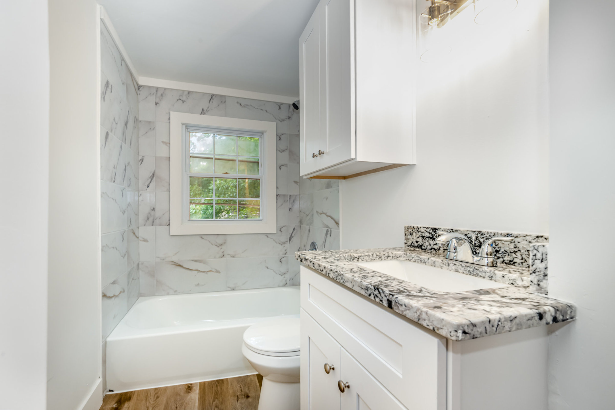 Beautiful brand new bathroom with gorgeous stone tile and countertops.